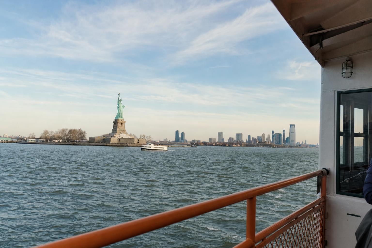 AI-generated illustration: A visitor ferry approaching Liberty Island with the Statue of Liberty and New York Harbor in the background