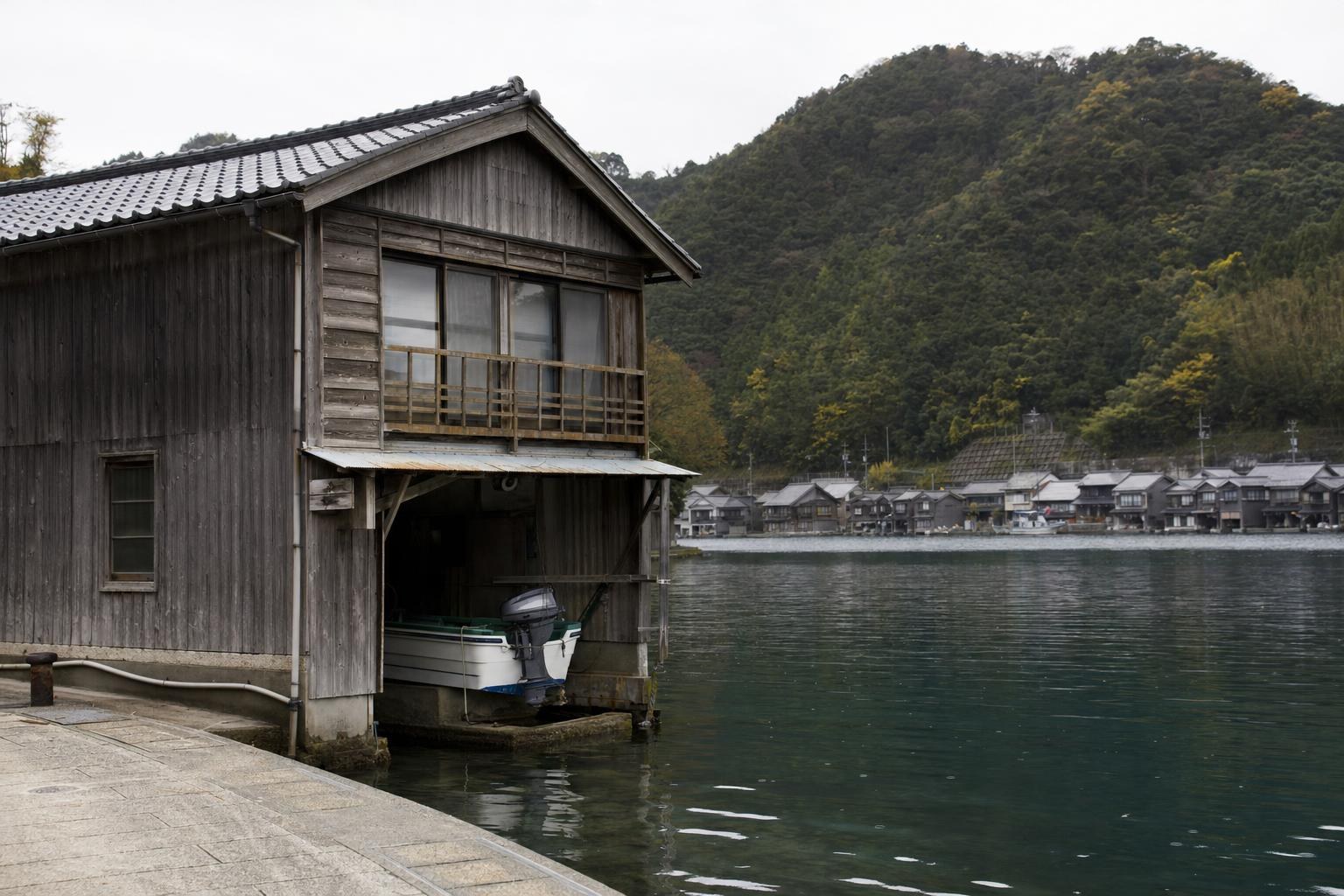 AI-generated illustration: A single funaya wooden boat-house on Ine Bay’s edge, Kyoto Prefecture, Japan