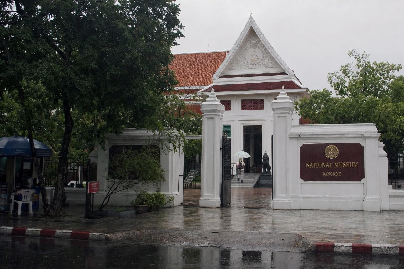 AI-generated illustration: entrance of the Bangkok National Museum on a rainy day in Rattanakosin, Bangkok, Thailand